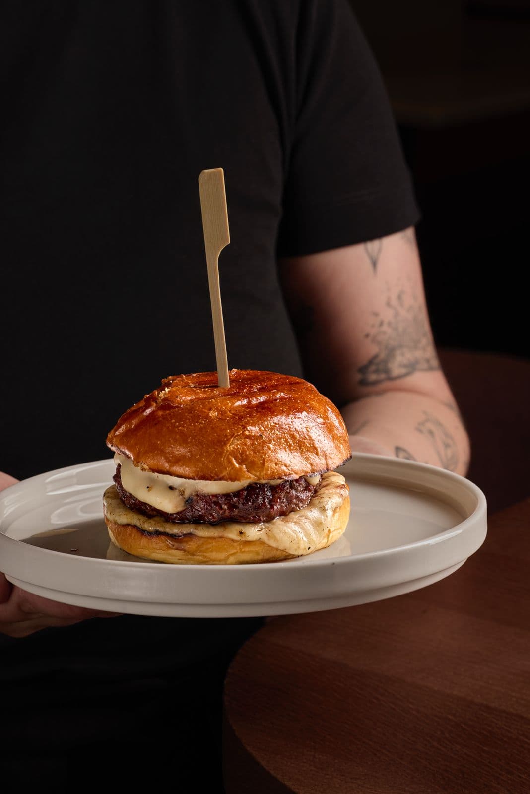 Hamburguesa 5 Gallos con salsa de queso en pan brioche