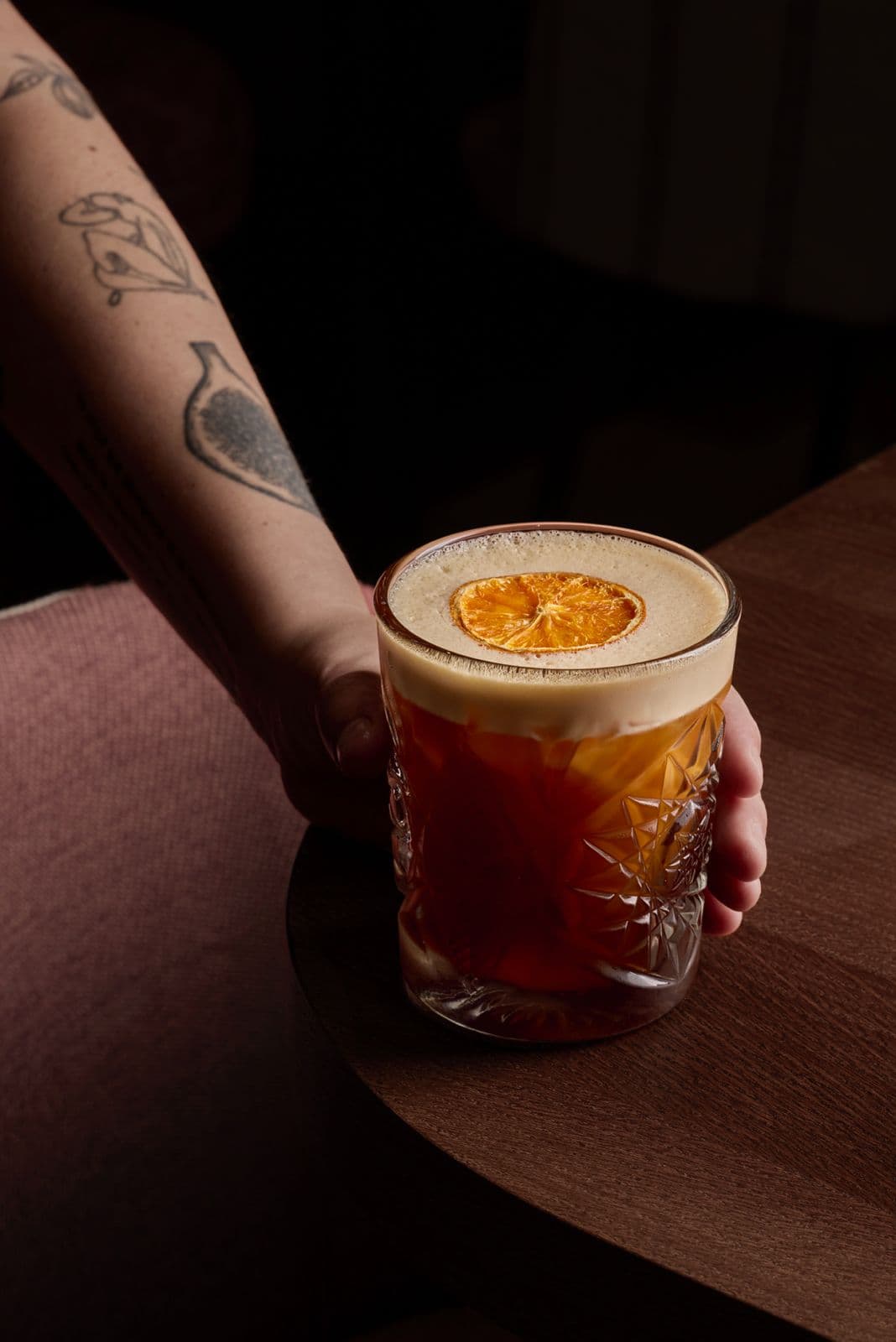 Carajillo con espuma y naranja deshidratada servido sobre la mesa