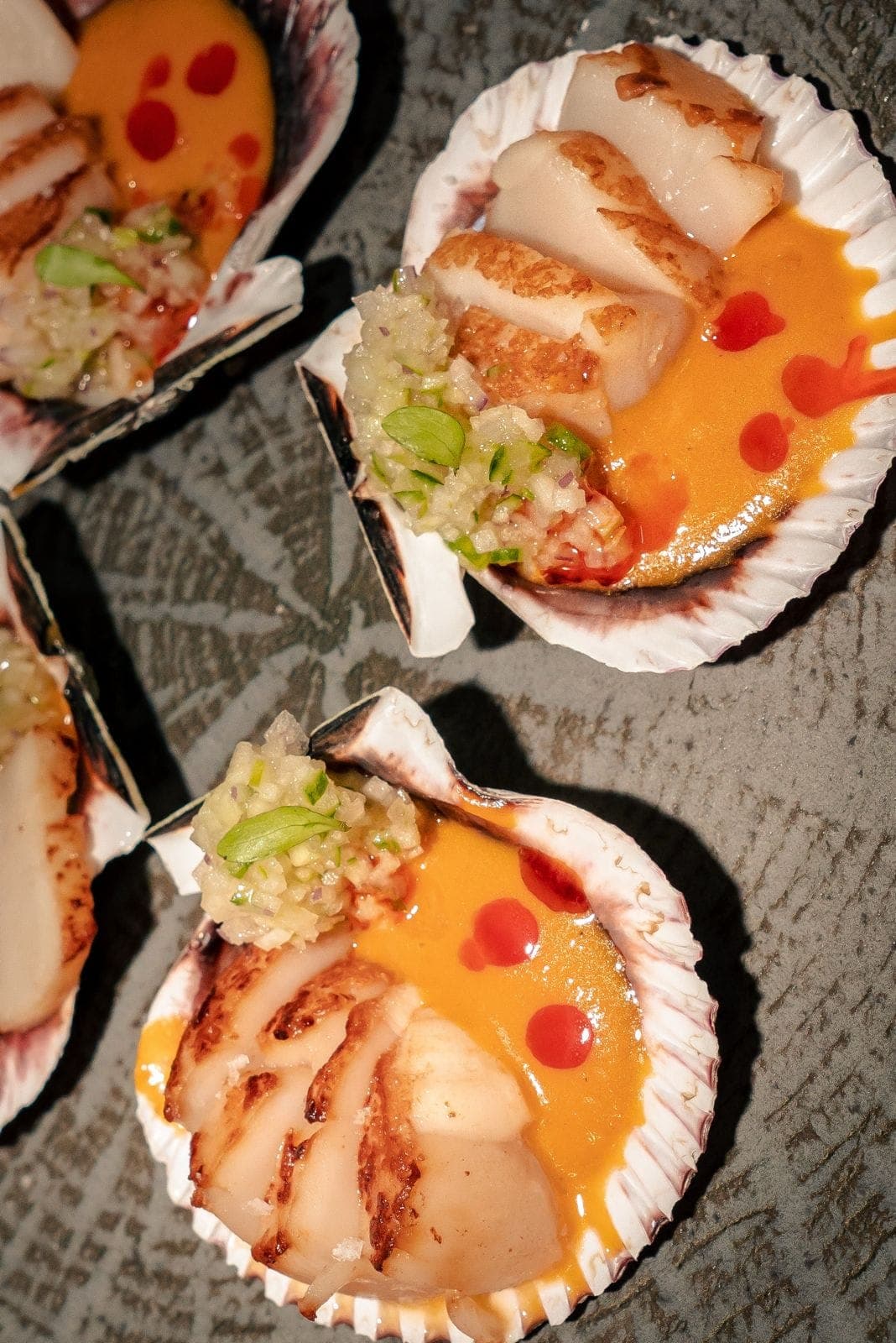Vieira a la plancha en su concha, con salsa tropical y picada